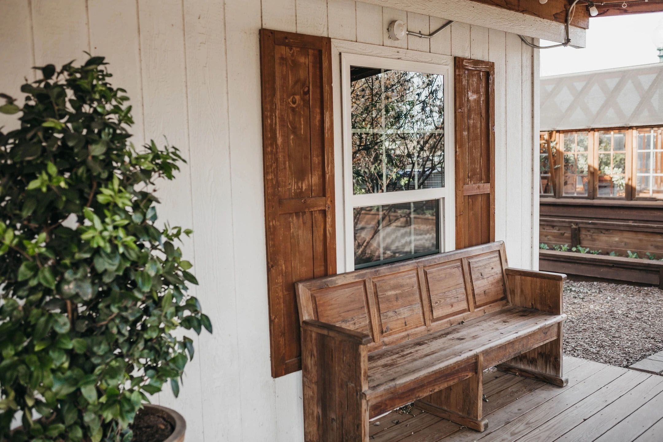 A wooden bench sitting in front of a window.