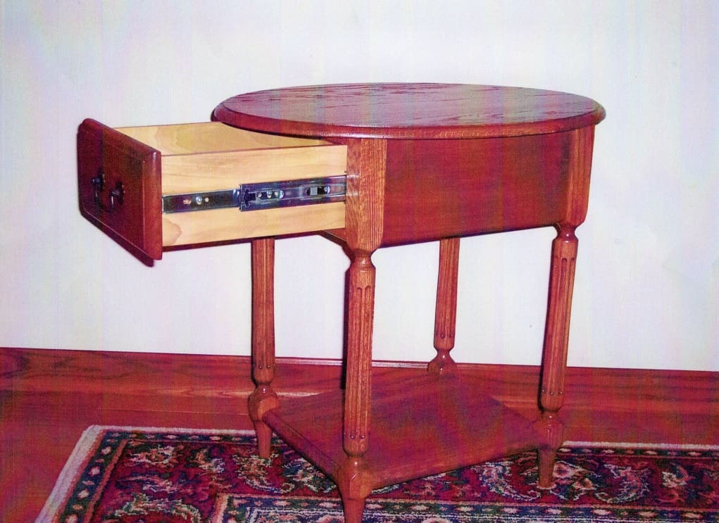 A table with a drawer and a shelf on top.