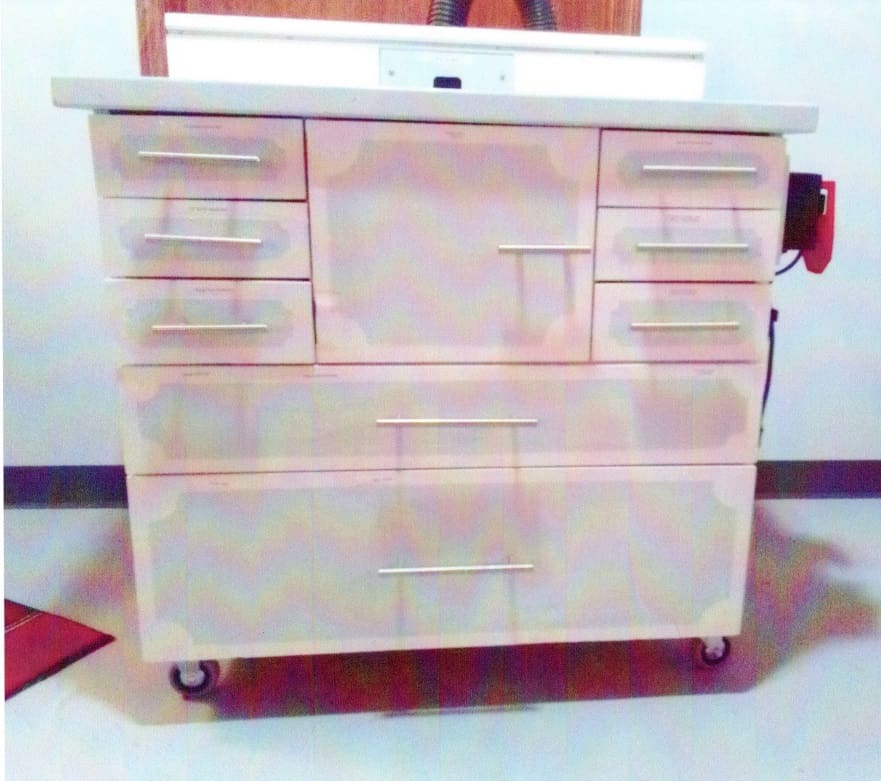 A large white cabinet with many drawers and wheels.