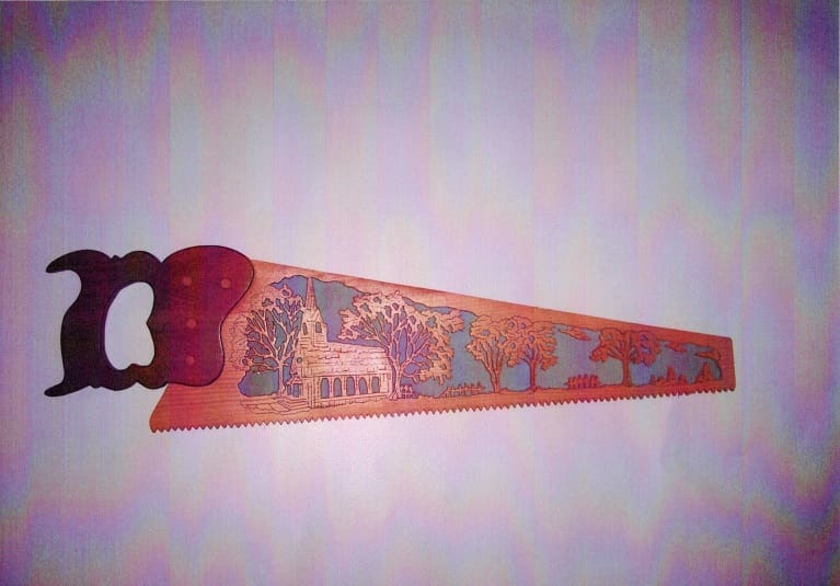 A wooden saw with an animal design on it.